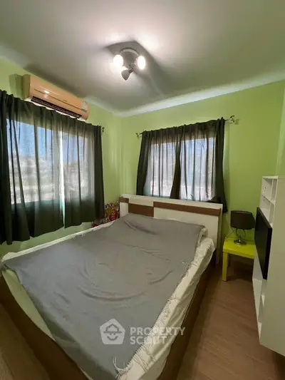 Cozy bedroom with modern furnishings and natural light in a stylish apartment.