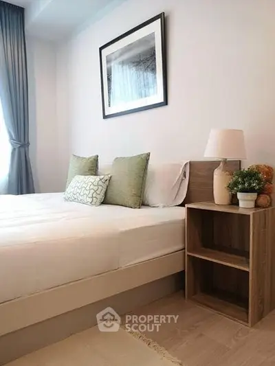 Modern bedroom with stylish decor and natural light, featuring a cozy bed and elegant furnishings.