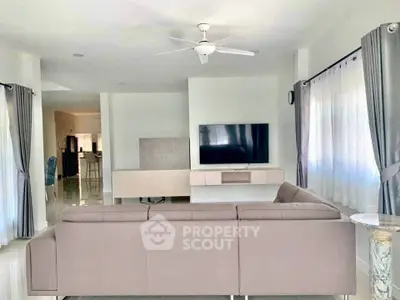 Spacious modern living room with sleek furniture and large TV