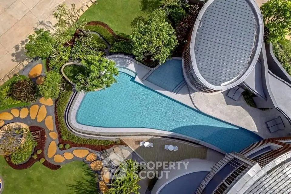Stunning aerial view of modern architectural building with luxurious pool and landscaped garden.