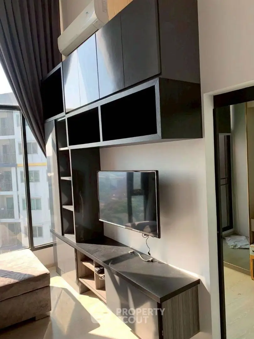 Modern living room with sleek black cabinetry and large window view