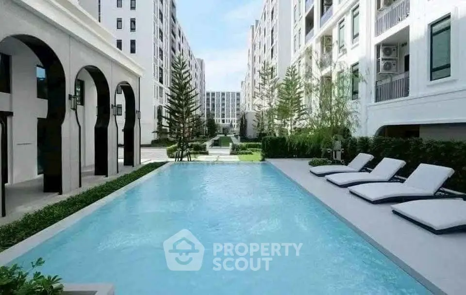 Luxurious apartment complex with a pristine outdoor pool and modern architecture.