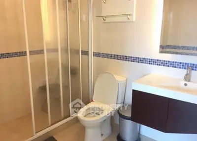 Modern bathroom with glass shower and sleek vanity in a contemporary home.