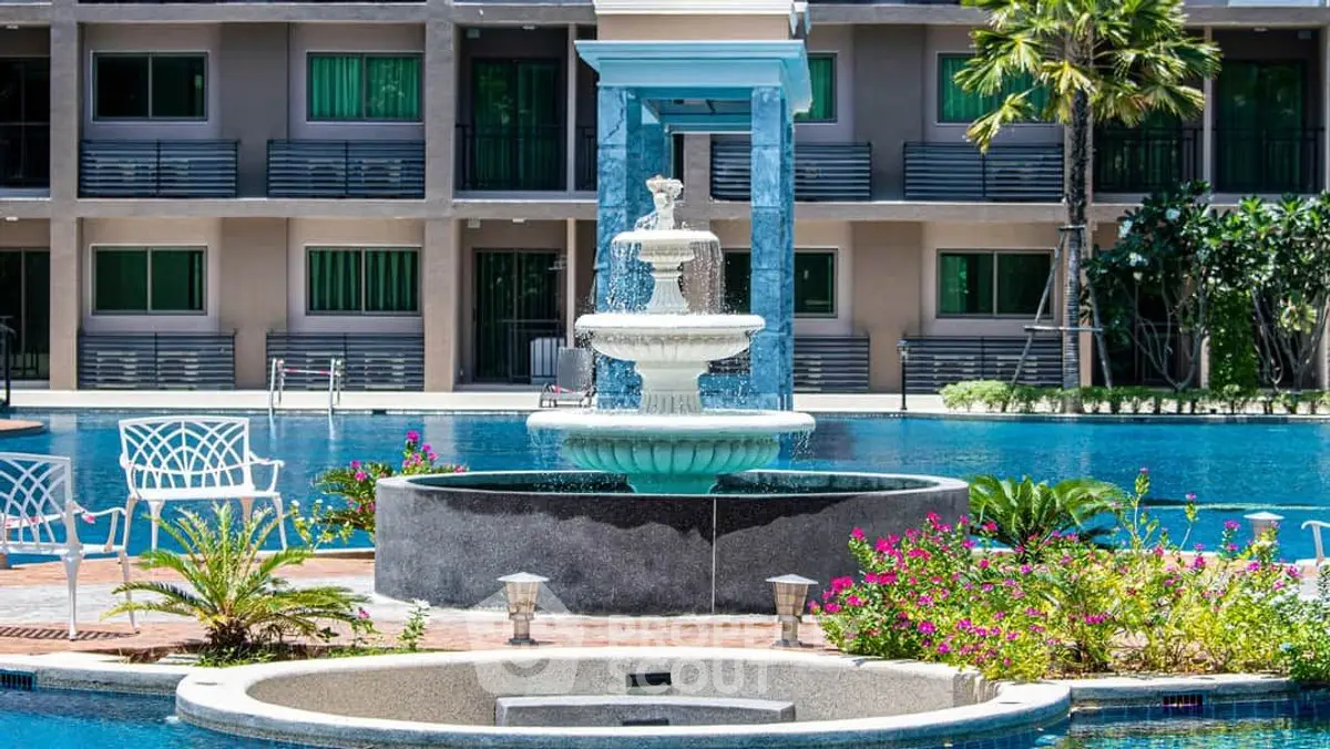 Luxurious poolside view with elegant fountain and lush greenery in upscale residential complex.