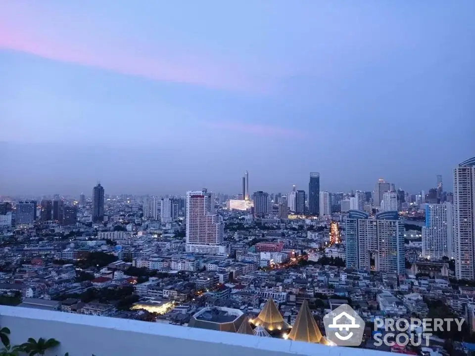 Stunning cityscape view from a high-rise building at dusk, showcasing urban skyline and vibrant city lights.