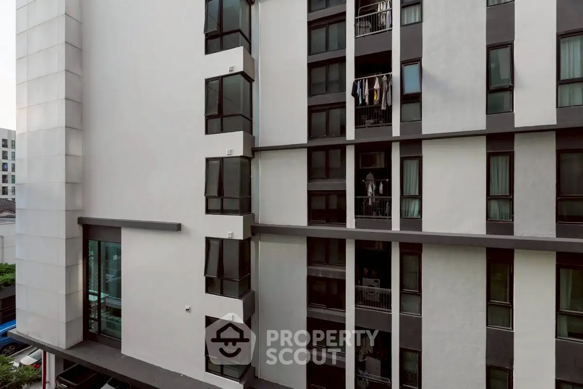 Modern apartment building exterior with sleek design and large windows.