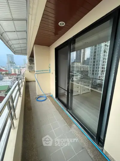 Spacious balcony with city view and sliding glass doors in modern apartment