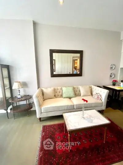 Charming living room with elegant sofa, stylish mirror, and vibrant red rug for a cozy ambiance.