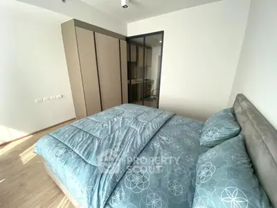 Modern bedroom with stylish bedding and ample closet space in a bright apartment.