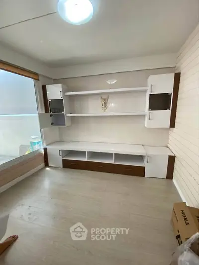 Modern living room with built-in shelving and large window for natural light