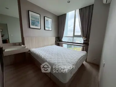 Modern bedroom with large window and stylish decor, offering a bright and inviting atmosphere.