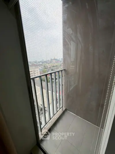 Cozy balcony with city view and safety netting, perfect for relaxation.