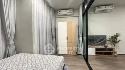 Modern bedroom with mirrored wardrobe and air conditioning in stylish apartment.