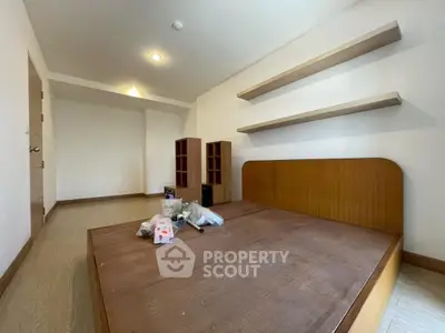 Spacious bedroom with wooden bed frame and minimalist shelves