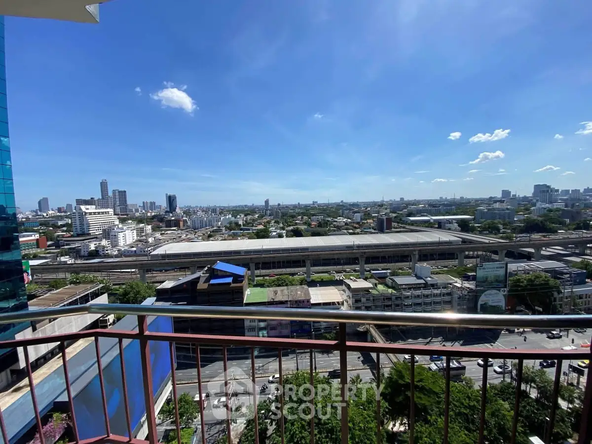 Stunning cityscape view from a high-rise balcony with clear blue skies.