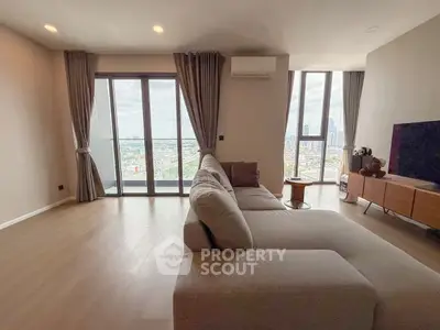 Spacious modern living room with panoramic city view and elegant furnishings.