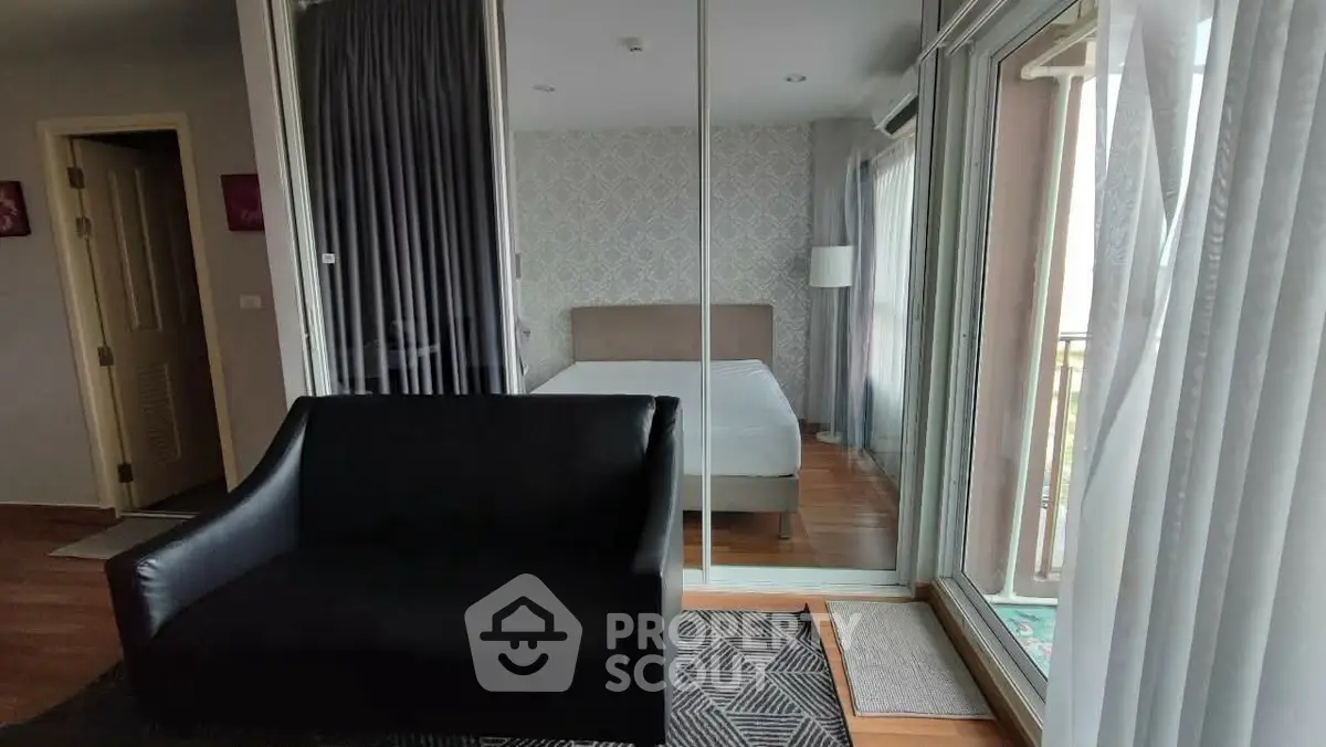 Modern bedroom with glass doors and cozy black sofa