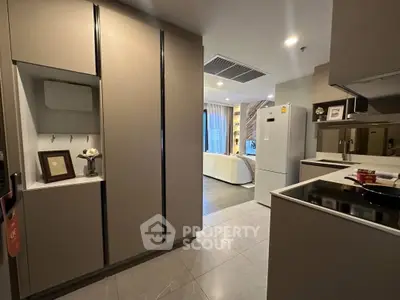 Modern kitchen with sleek cabinetry and open layout leading to a stylish living area.