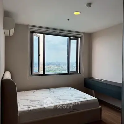 Modern bedroom with large window offering stunning city view, featuring minimalist design and natural light.