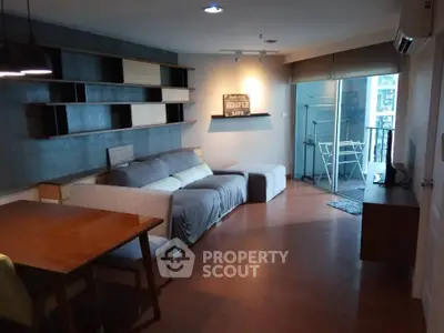 Modern living room with stylish furniture and balcony access in urban apartment.