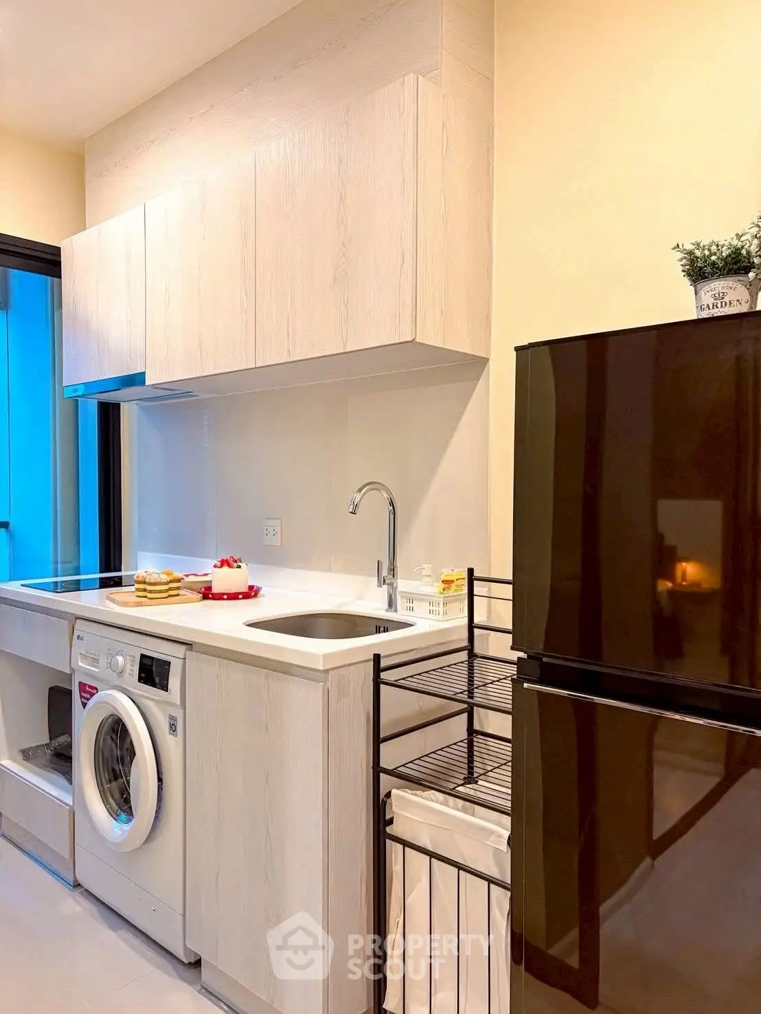 Modern kitchen with sleek appliances and washing machine in stylish apartment.