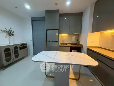 Modern kitchen with sleek cabinetry and marble island in contemporary apartment