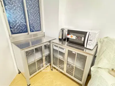 Compact kitchen corner with microwave and kettle on sleek metal cabinets