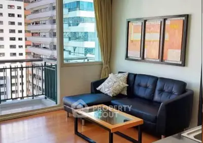 Modern living room with black leather sofa and city view balcony