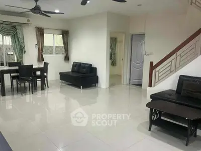 Spacious modern living room with sleek furniture and elegant staircase in a contemporary home.