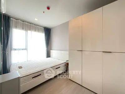 Modern bedroom with large window and sleek white wardrobe