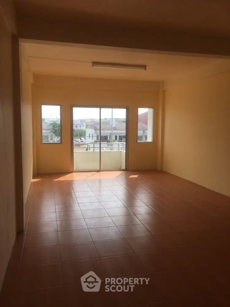 Spacious unfurnished room with large windows and tiled floor, perfect for customization.