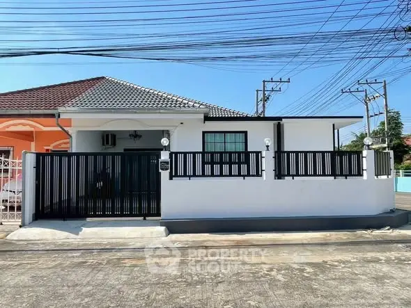 Charming single-story home with modern fence and tiled roof in a serene neighborhood.