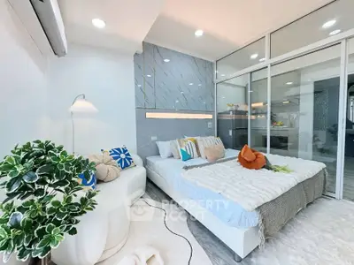 Modern bedroom with stylish decor and glass partition, featuring cozy bed and elegant lighting.