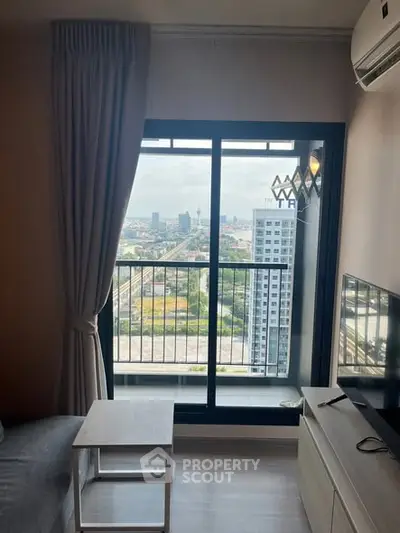 Modern living room with city view from high-rise apartment window.