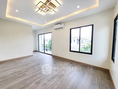 Spacious modern living room with large windows and elegant lighting