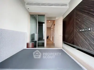 Modern minimalist bedroom with sleek design and built-in storage solutions.