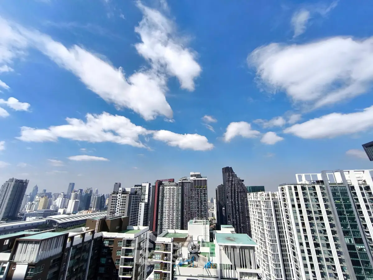 Stunning cityscape view from a high-rise building showcasing modern architecture under a clear blue sky.