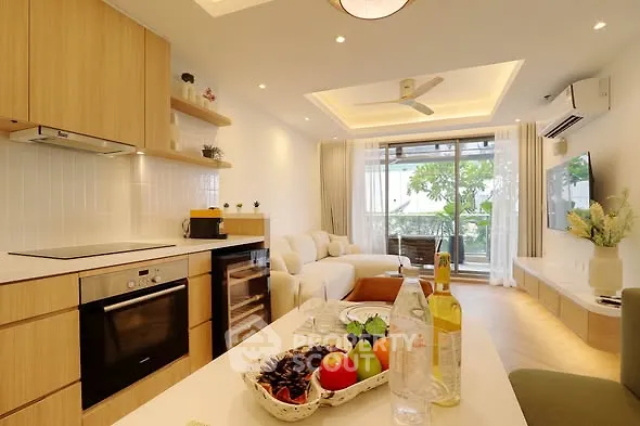Modern open-layout living room with kitchen, featuring sleek design and natural light.