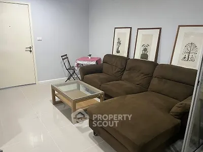 Cozy living room with brown sectional sofa, glass coffee table, and decorative wall art.