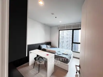 Modern bedroom with large window and stylish decor in urban apartment