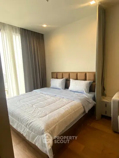 Cozy bedroom with modern decor and natural light, featuring a comfortable bed and elegant curtains.