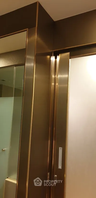 Luxurious bathroom with sleek metallic accents and frosted glass door