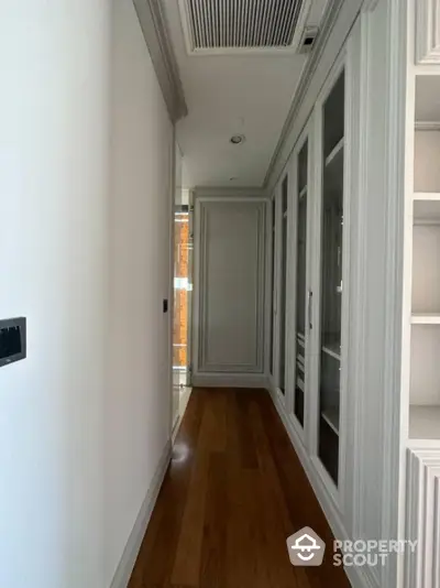 Elegant hallway with wooden flooring and built-in storage cabinets