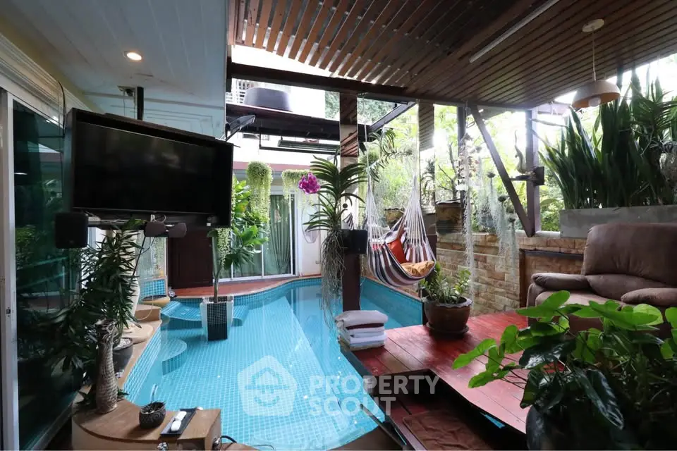 Luxurious indoor pool area with lush greenery and modern amenities, perfect for relaxation and entertainment.