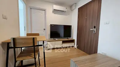 Modern living room with wooden flooring, TV, and dining set in a cozy apartment.
