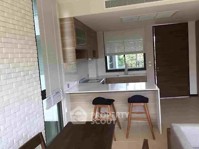 Modern kitchen with open layout, sleek cabinetry, and breakfast bar, ideal for entertaining and casual dining in a stylish home.