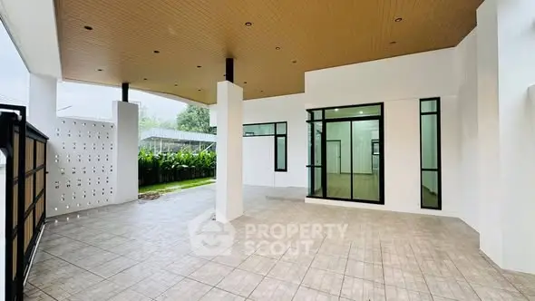 Spacious modern patio with tiled flooring and garden view, perfect for outdoor relaxation.