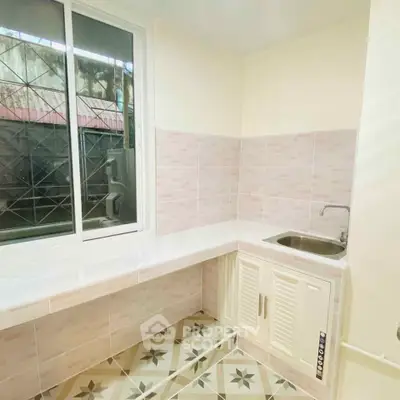 Charming kitchen with tiled backsplash and modern sink, perfect for culinary enthusiasts.