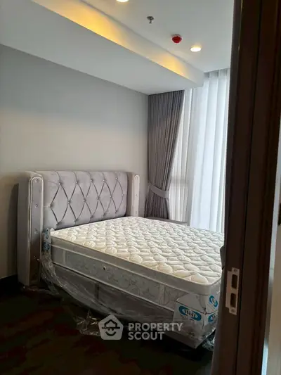 Modern bedroom with elegant bed and floor-to-ceiling curtains in a stylish apartment.