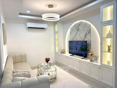 Elegant living room with modern decor, built-in TV unit, and stylish lighting.